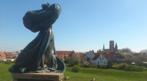 Dronnning Dagmar står på Slotsbanken og skuer ud over Ribe skyline.