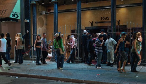 Hvad foregår der her? Hvad laver sparsomt klædte unge piger sammen med gadebande-typer, en pizza-spisende fyr og en trist rosesælgende mand? Står de i kø for at komme ind, er de gået ud for at få en smøg eller hænger der bare ud her? Og hvad foregår der bag gitteret? ... Alle er velkomne til at digte en fortælling ud fra det opstillede billede.